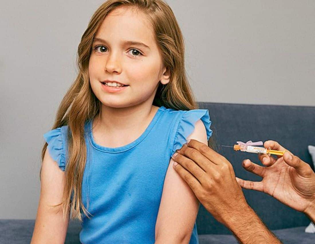 Young girl about to receive a vaccine in her upper arm