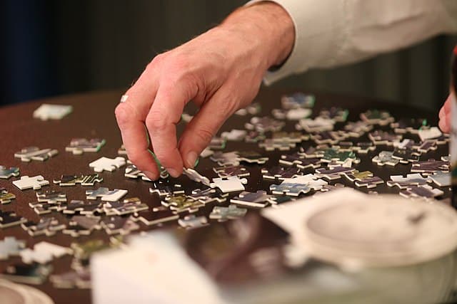 A man solving a jigsaw puzzle.