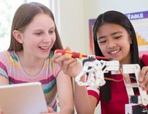 Two Female Pupils In Science Lesson Studying Robotics