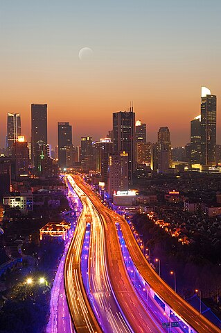 A city skyline with a road and buildings Description automatically generated with medium confidence