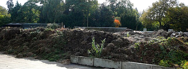 A dirt pile with trees in the background
Description automatically generated