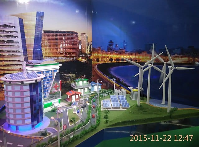A model of a city with windmills and buildings Description automatically generated