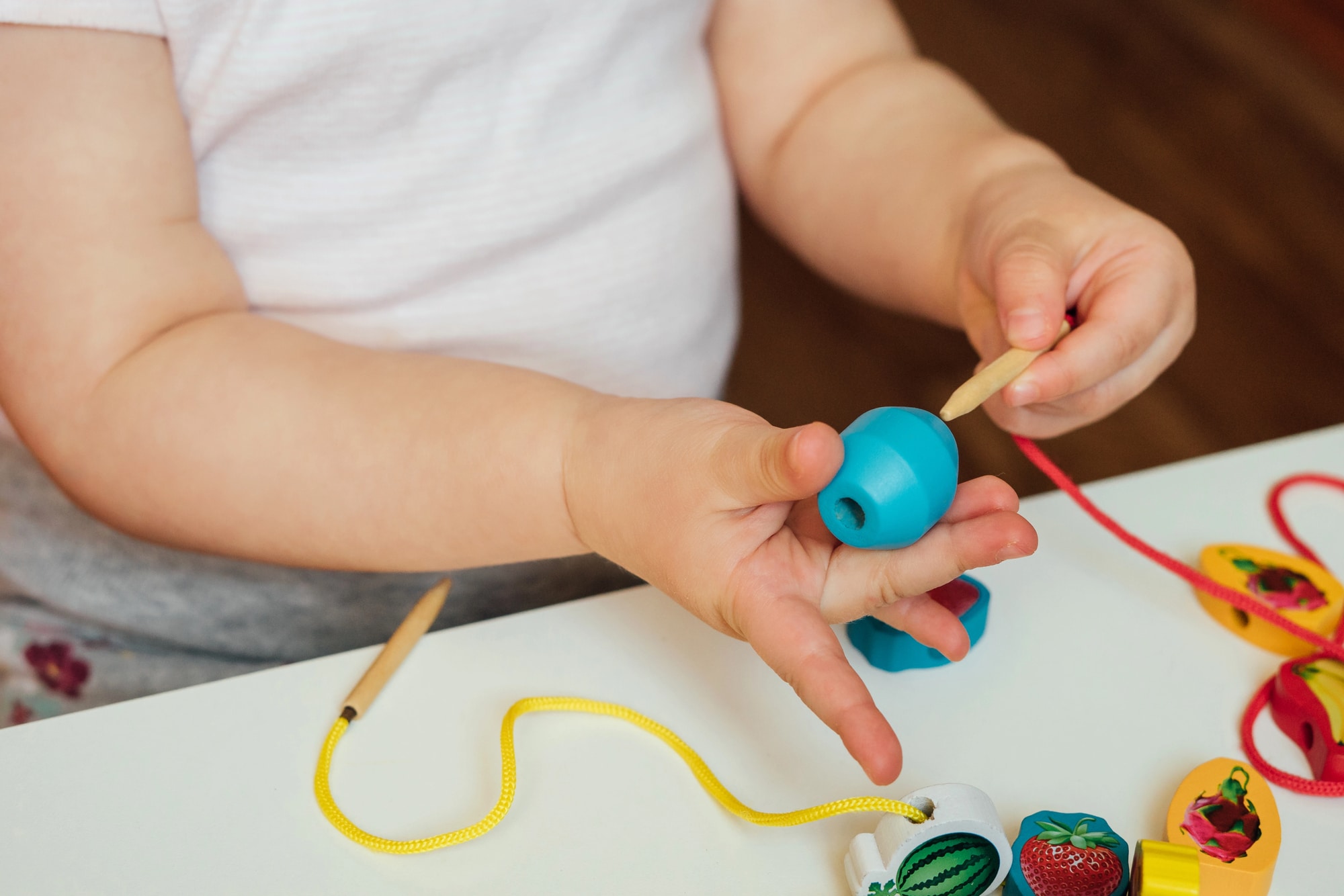 Child putting beads on a string